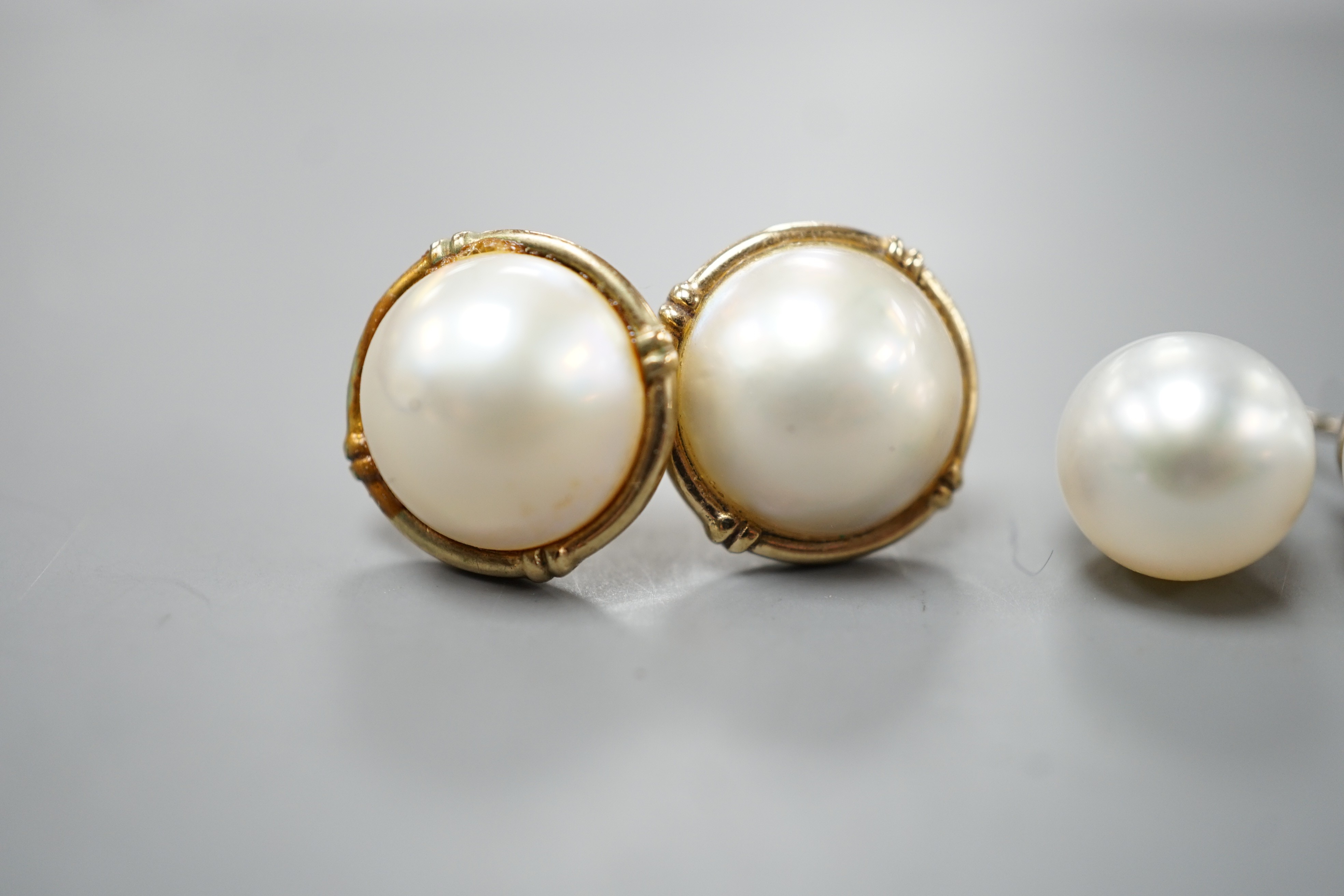 A pair of 18ct and cultured pear ear studs, a pair 9ct gold and mabe pearl ear studs and a pair of 18k, cultured pearl and diamond set ear studs (all lacking butterflies).